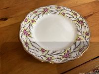 Front view showing floral pattern, scalloped gold edge