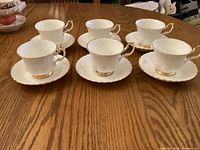 Six Royal Albert Val D'Or teacups on matching saucers displayed on table