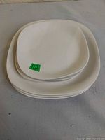 Stack of six white square plates