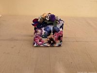 Front view of purse-shaped floral music box