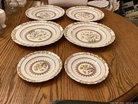 Six Spode Buttercup pattern plates on table