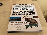 Front cover of the hardcover book showing title, authors, images of fish and lures