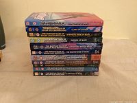 Stack of 11 paperback novels showing spines and titles