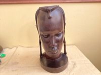 Front view of carved African male bust showing face and base