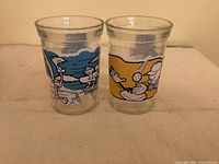 Front view of both Welch’s Looney Tunes glasses showing blue and yellow printed scenes
