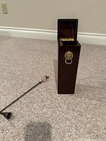 Wooden match holder box open with metal snuffer alongside