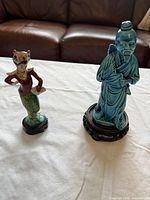 Both figurines side by side to show relative size and style