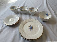 Full set laid out: plates, bowl, saucers, teacups