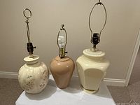 All three ceramic lamp bases with harps visible, no shades