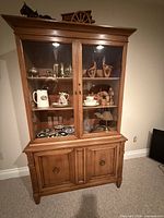 Full view of china cabinet showing upper glass doors, shelves, crown molding