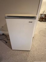 Front view of white Danby mini fridge, closed