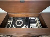 Open lid view showing turntable, control panel, cassette deck and record storage