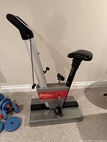 Side view of Universal upright stationary bike showing frame, saddle, pedals and console