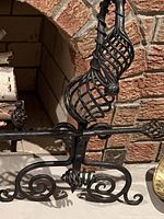 Close view of grate front scroll, decorative twisted finial, scroll feet