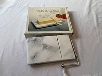 marble cheese slicer in front of box