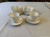 Six Royal Albert demitasse cups on saucers, arranged upright and on side