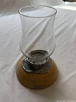 Full view of Royal Selangor oil lamp showing glass chimney, pewter coil and wood base with nameplate