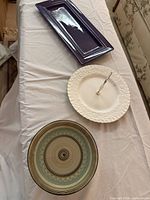Purple rectangular platter, white plate with handle, multicolor platter displayed on table