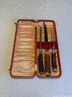 Three-piece carving set—knife, fork, sharpener—in red fabric-lined case
