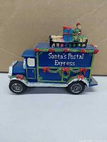 Left side view showing "Santa's Postal Express" text, wreath and roof gifts
