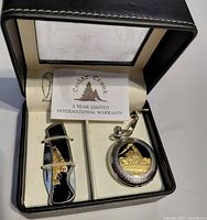 Open presentation case showing pocket watch, pocket knife, warranty card