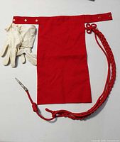 Bib scarf, gloves, and shoulder cord laid out together