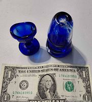 Miniature goblet and conical paperweight beside dollar bill showing size