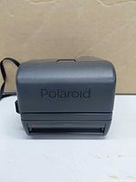 Front of closed Polaroid OneStep Closeup camera showing Polaroid logo