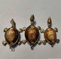 Front view of all three cowrie shell turtle pendants