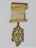Full view of medal with attached ribbon and clasps