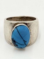 Front view showing turquoise cabochon and wide silver band