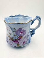 Mustache cup front showing rose decoration, blue gradient and gold rim