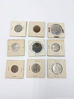 Front view of nine coins in 3×3 grid within cardboard flips