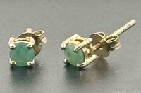 Front view of both emerald studs showing stones and prong settings
