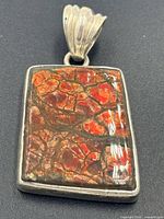 Front view of rectangular ammolite pendant showing Dragonskin pattern and silver bezel