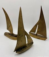 Front view three brass sailboats