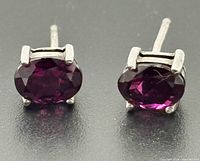 Front view of both amethyst stud earrings showing four-claw sterling settings