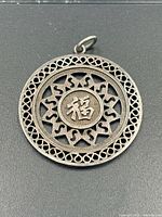 Front view of sterling silver medallion pendant showing lattice border and central 福 character