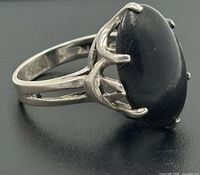 Side profile of sterling silver ring highlighting split shank and prong setting of black onyx