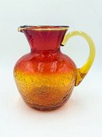 Side view of Amberina crackle glass pitcher showing color gradient and crackle texture
