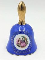 Front view showing cobalt blue bell, gold handle, and courting scene medallion