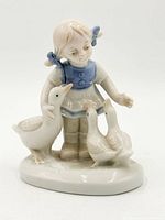Front view of porcelain figurine showing girl, goose and two ducks