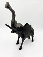 Left-front view of bronze elephant figurine, trunk raised