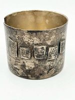 Front view showing plaques spelling SUGAR and patina