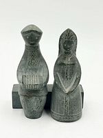 Front view showing both figures, incised details, accordion, hood