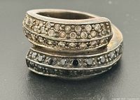 Front view of bypass ring showing clear stones on one arc and black stones on the other