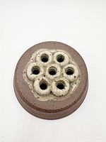 Top view showing circular stoneware body and seven cream-glazed openings