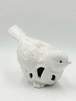profile view of glazed ceramic bird showing embossed feathers and cutouts