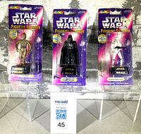 Front view of three sealed Star Wars figurine stampers on display stands