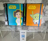 Front view of both Star Wars journals showing Princess Leia and Yoda covers with pencils attached